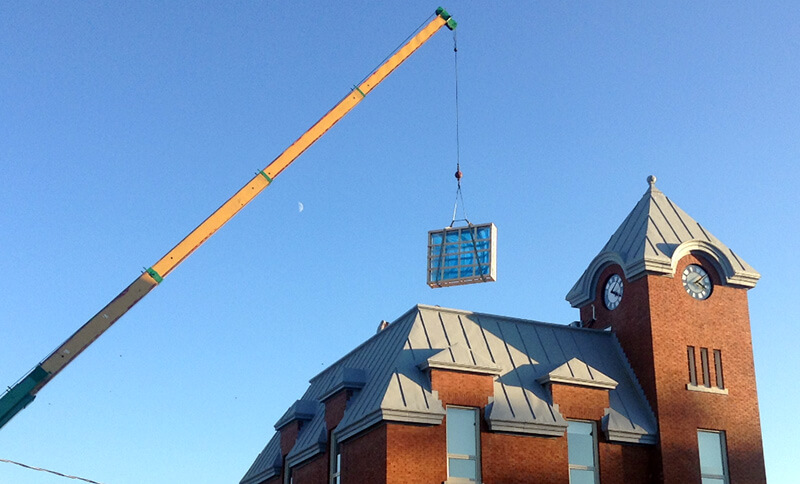 skylight hoisted onto roof of harriston old post office