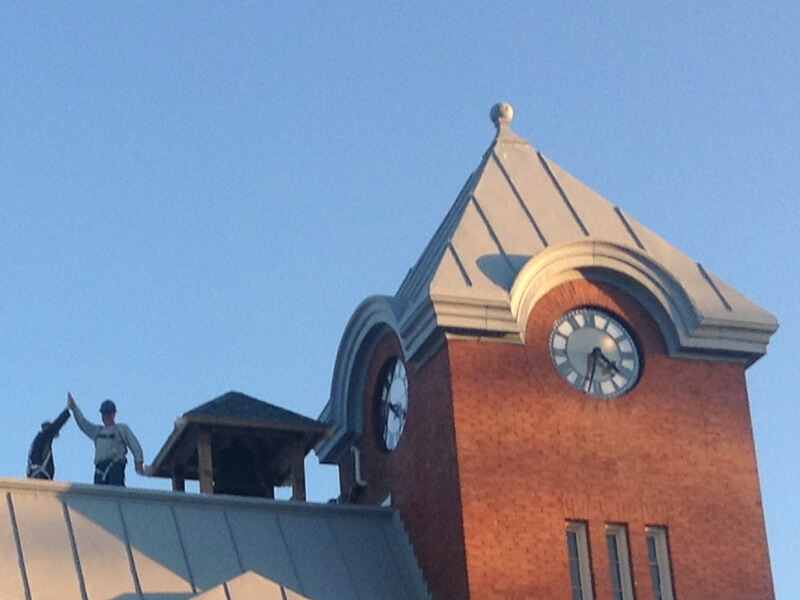 contractors high five on roof of harriston old post office